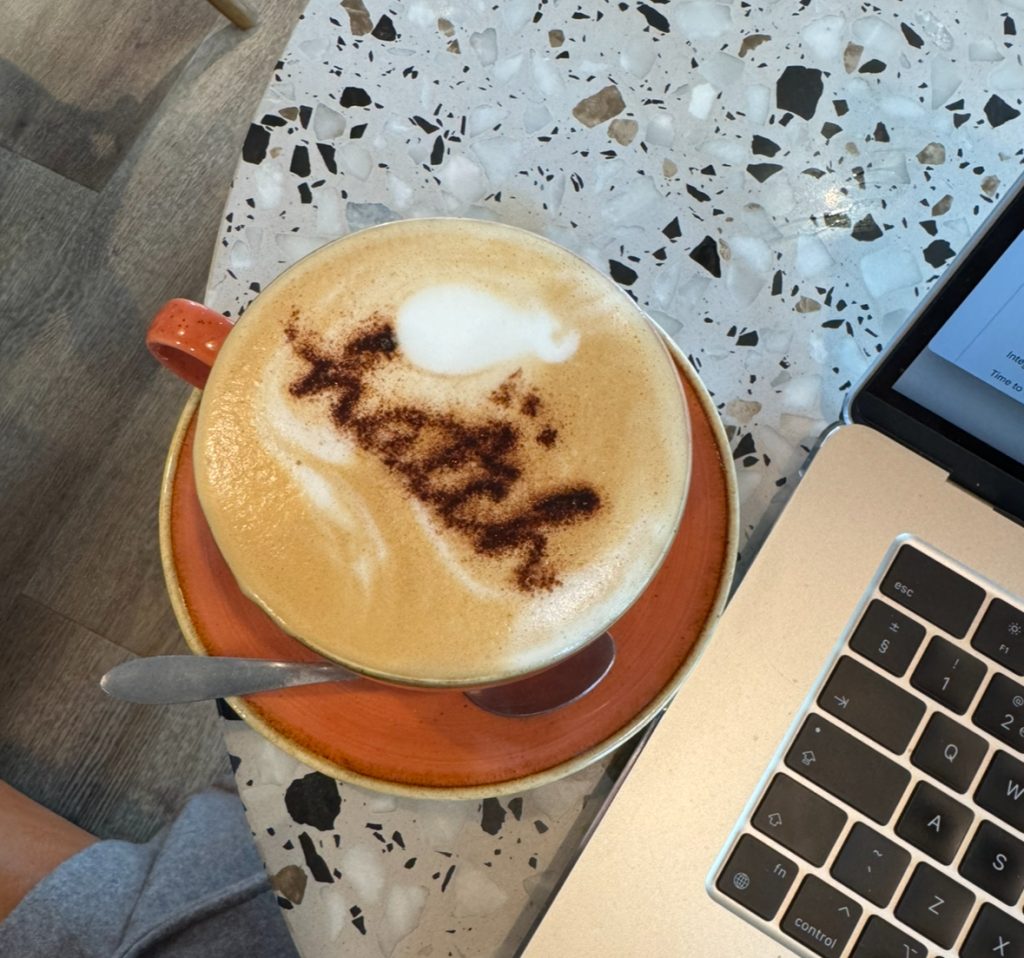 coffee with a "hatch" logo in cocoa powder on top